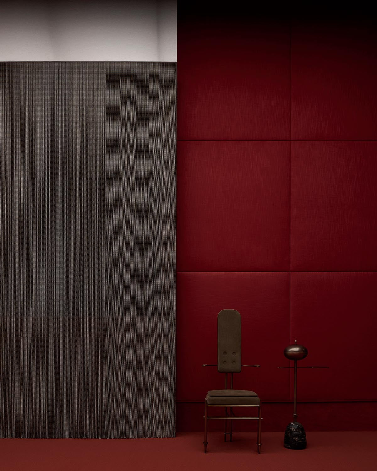 Minimalist interior with a textured dark gray wall panel, deep red padded wall, vintage chair, and sculptural side table.