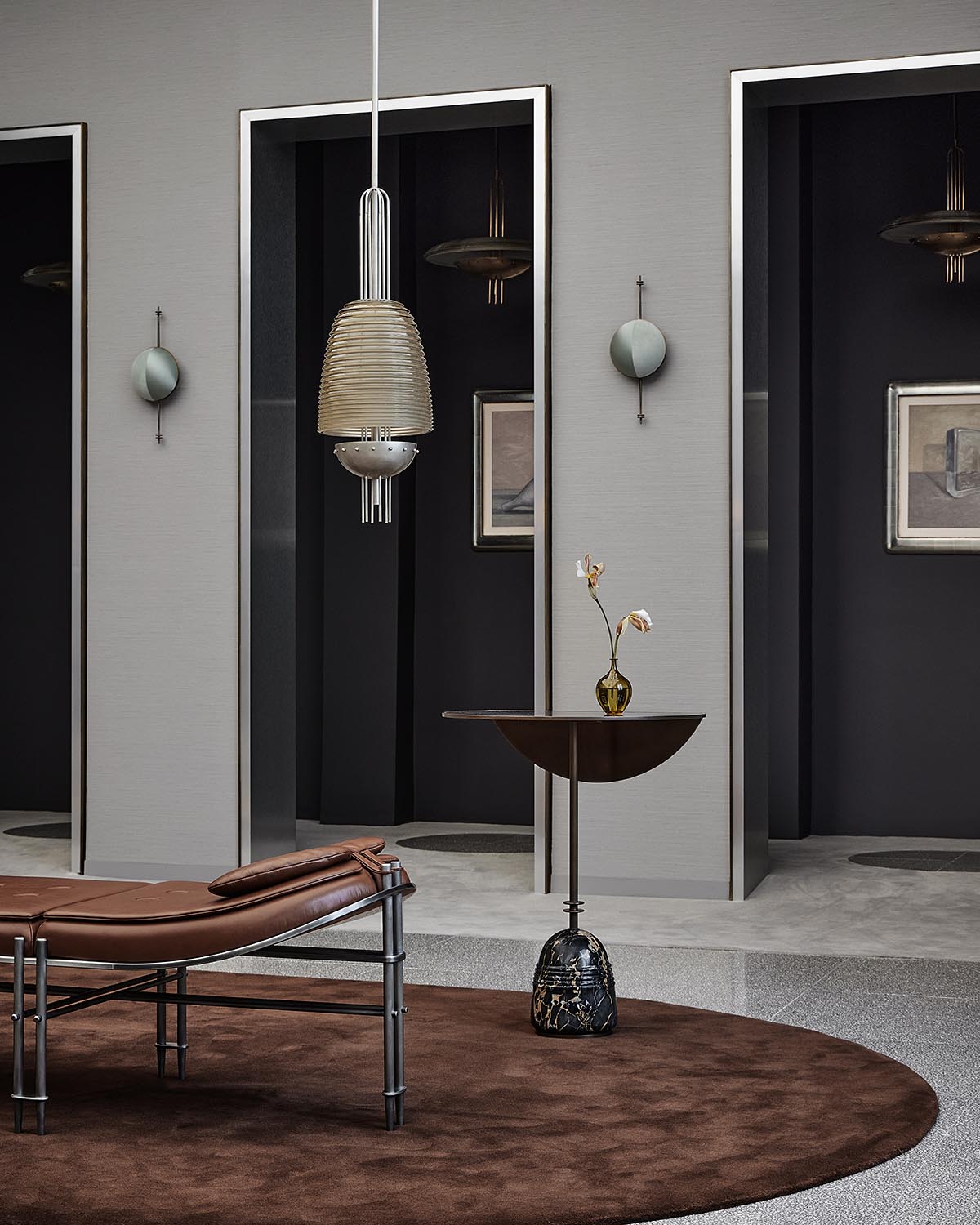 Modern bistro table with dark semi-circular top and sculptural black marble base, styled with minimal decor on brown rug