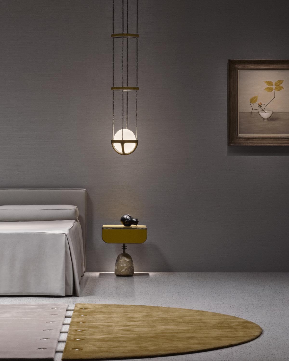 Minimalist bedroom corner with beige upholstered bed, mustard yellow side table on stone base, round pendant light, and framed botanical print