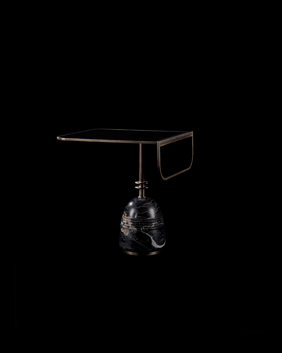 Square black side table with a brass frame and sculpted black marble base against dark background