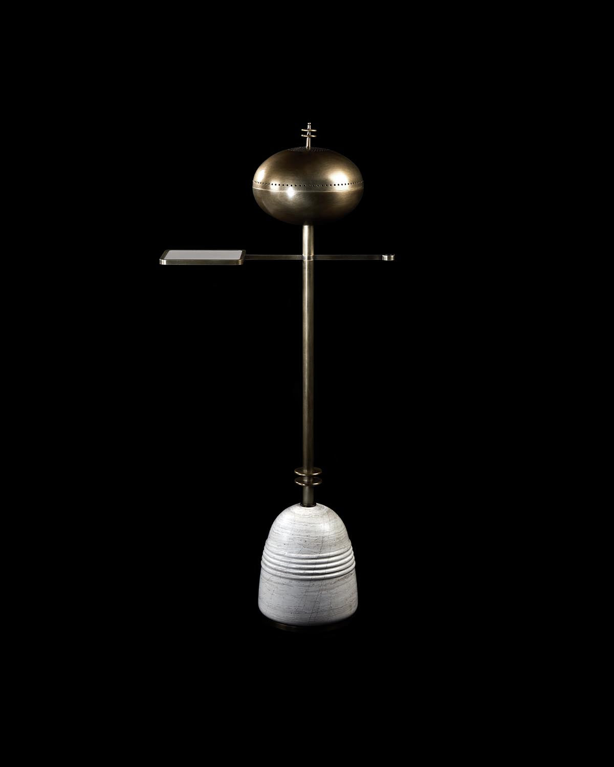 Minimalist standing smoking table with round brass top, horizontal metal tray, and ribbed concrete base on black background