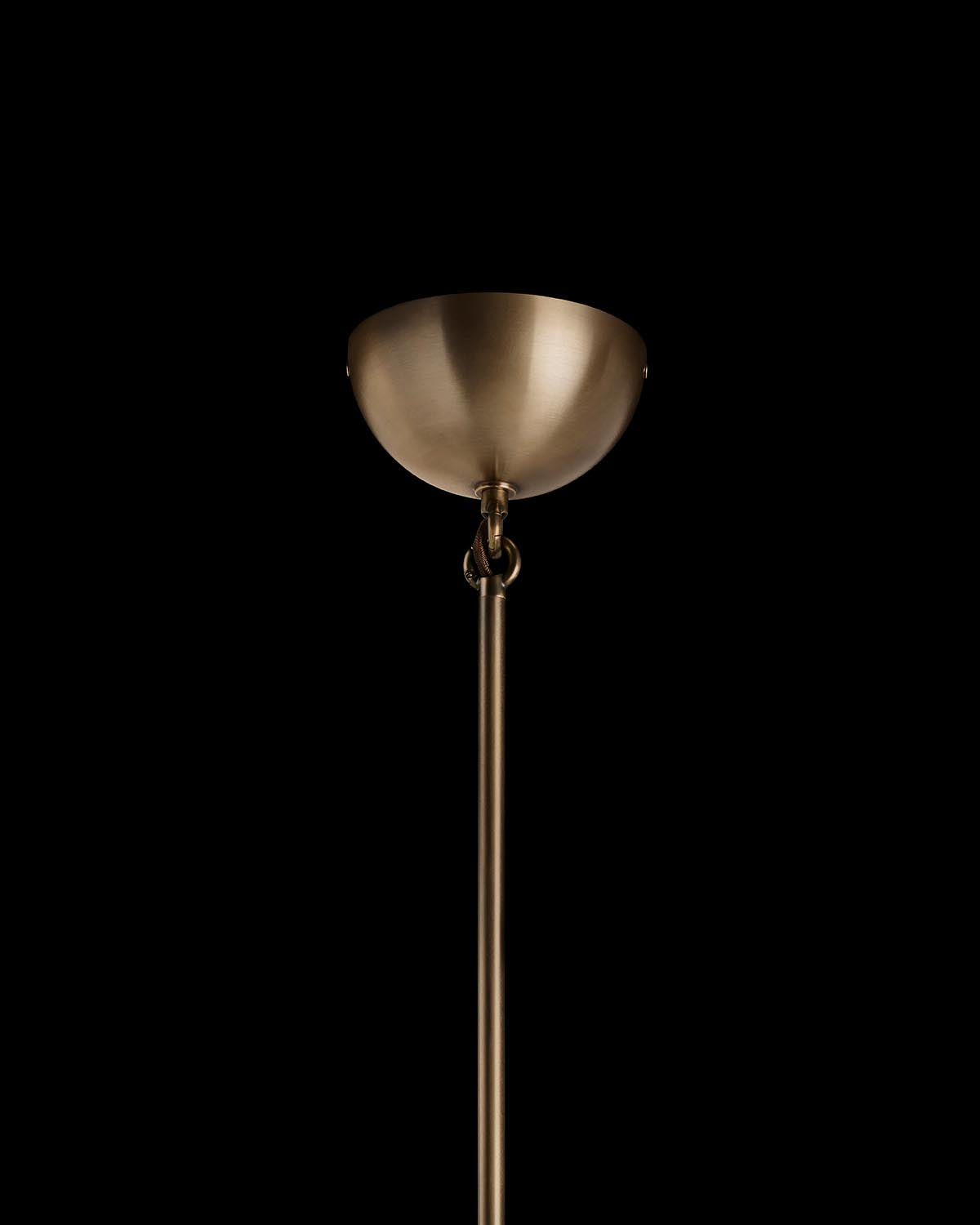 Brushed brass ceiling canopy with a narrow rod extending downward against a black background
