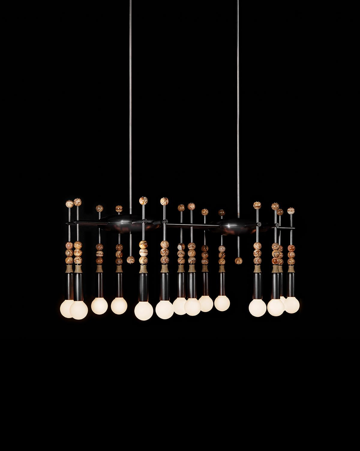 Modern rectangular pendant light fixture with multiple glowing bulbs and decorative wooden accents against black background