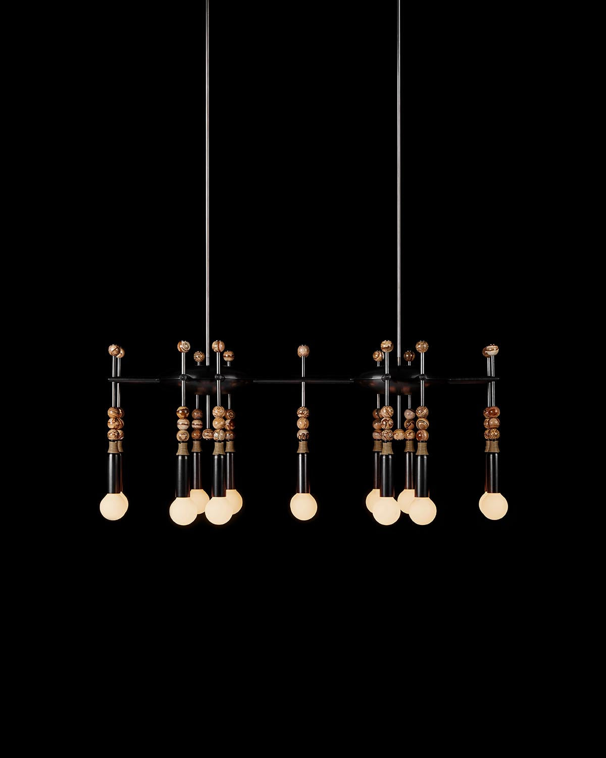 Modern black metal chandelier with hanging light bulbs and decorative wooden beads against black background
