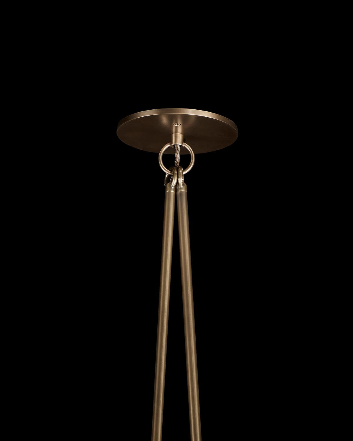 Brushed brass ceiling mount with two long rods suspended from interlocking circular hooks against black background