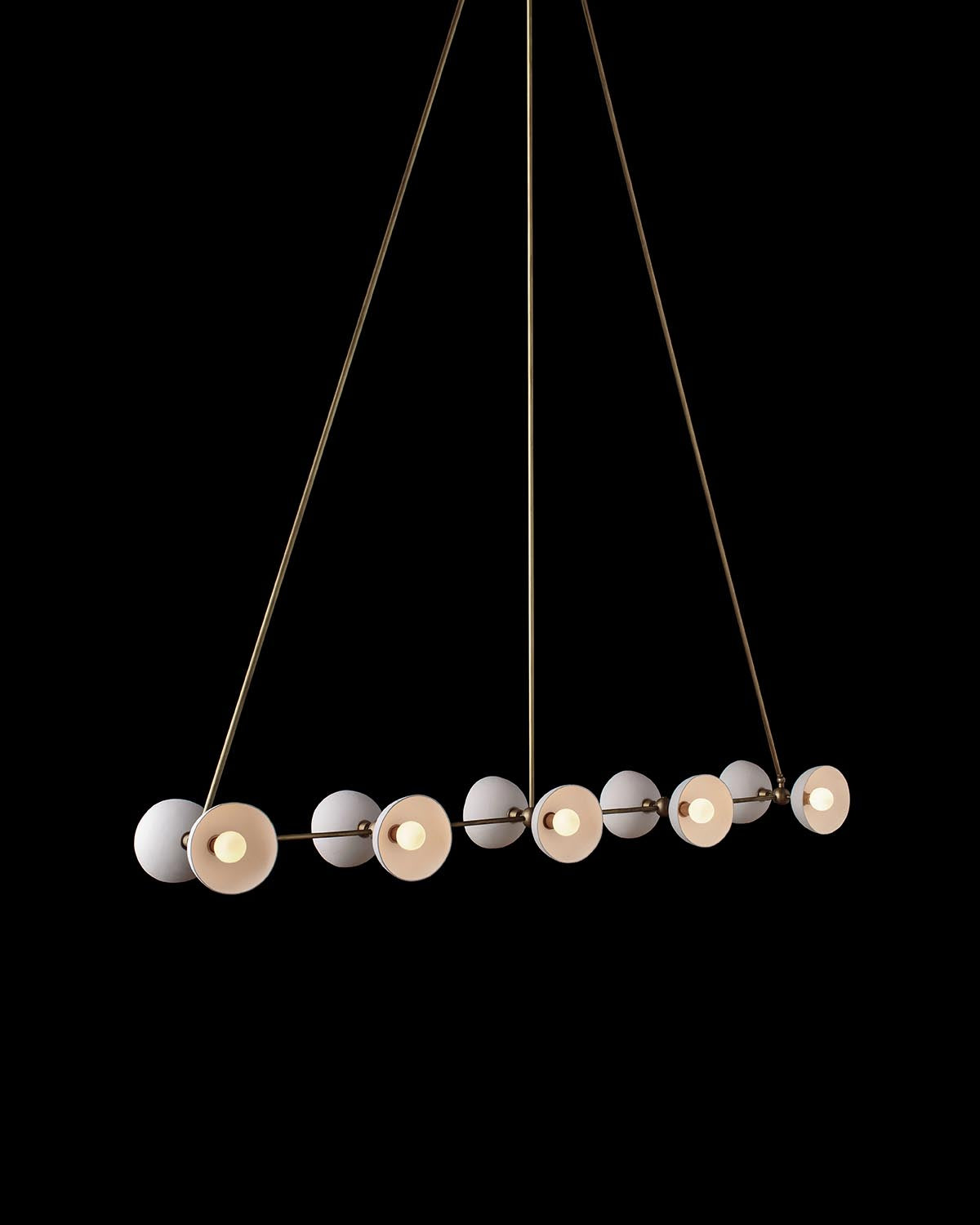 Linear pendant light with ten evenly spaced round diffusers and slim metallic rods against a black background