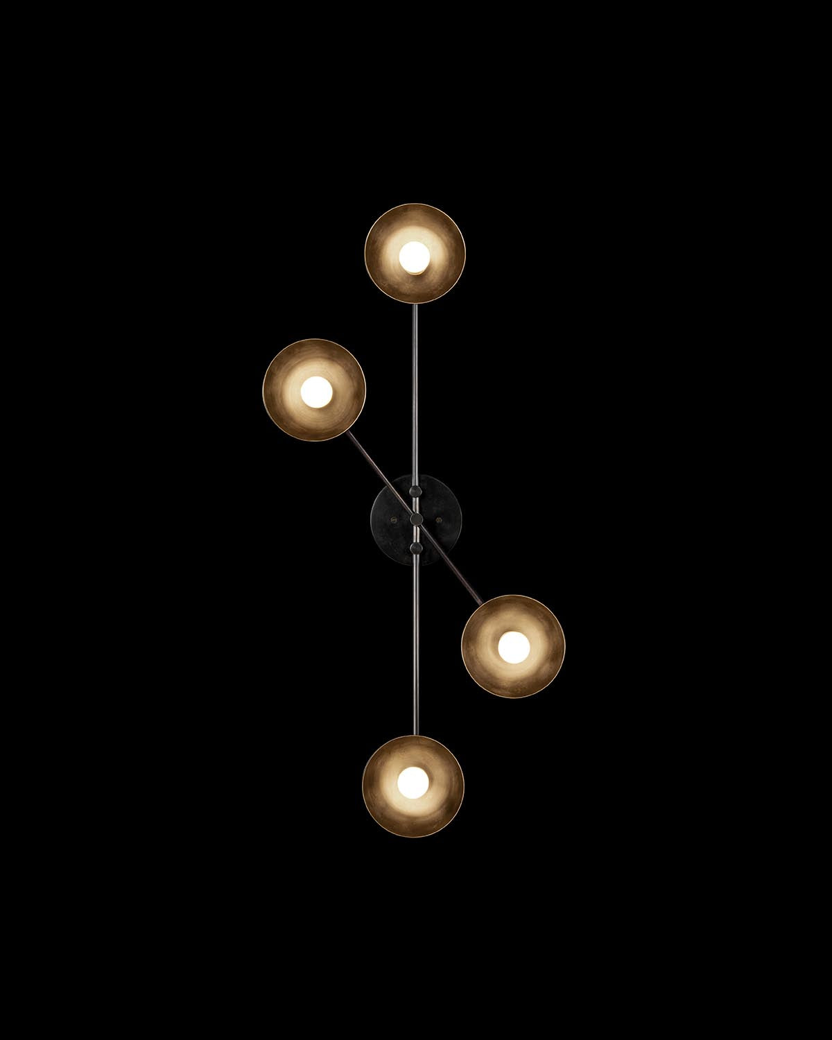 Overhead view of TRAPEZE 4 SURFACE light fixture with four circular bulbs on intersecting metal rods against black background