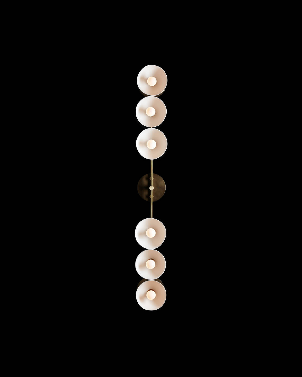 Top-down view of a vertical row of six round white light fixtures with warm bulbs on a dark background