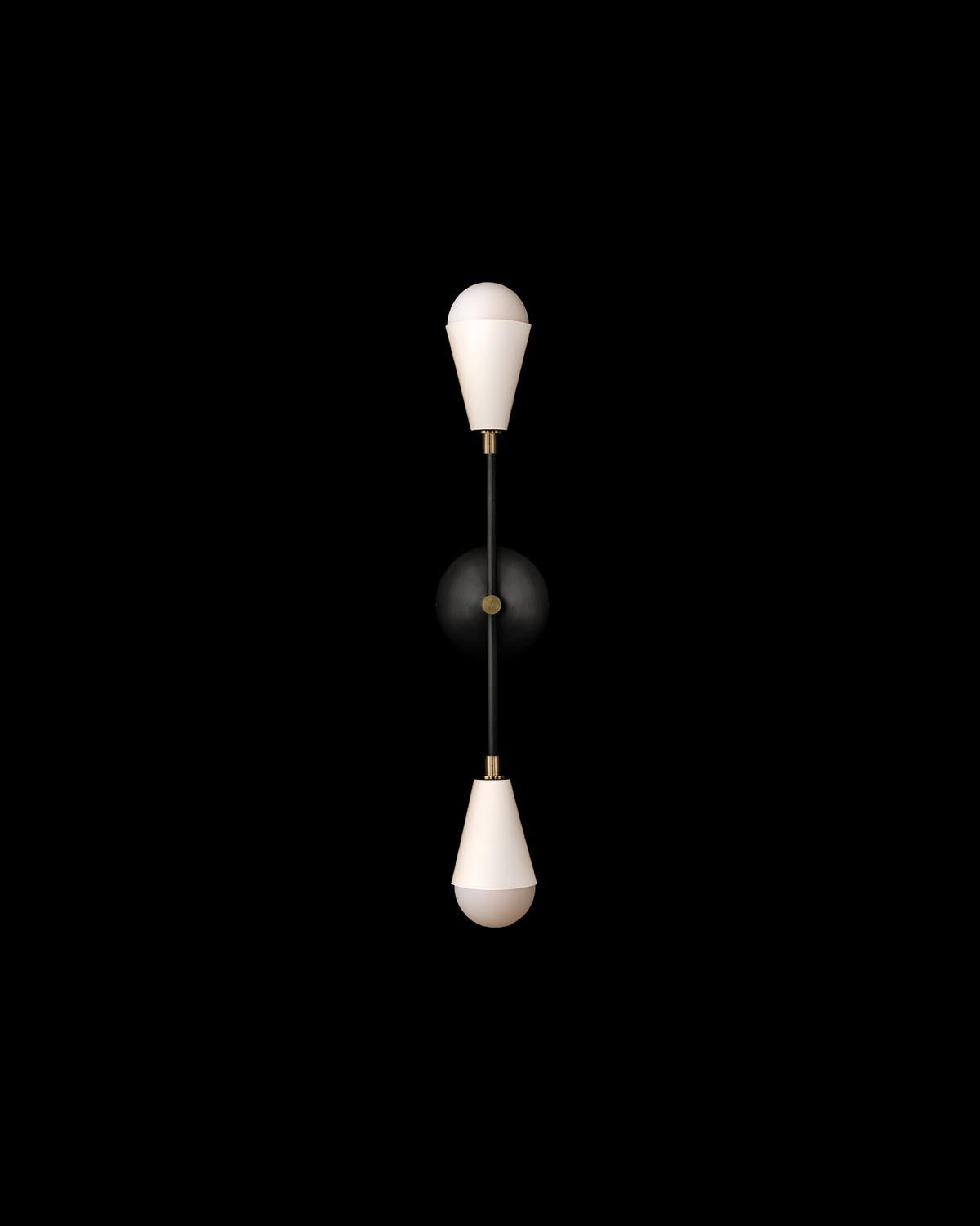 Minimalist vertical wall sconce with two white conical shades connected by a slender black rod on black background