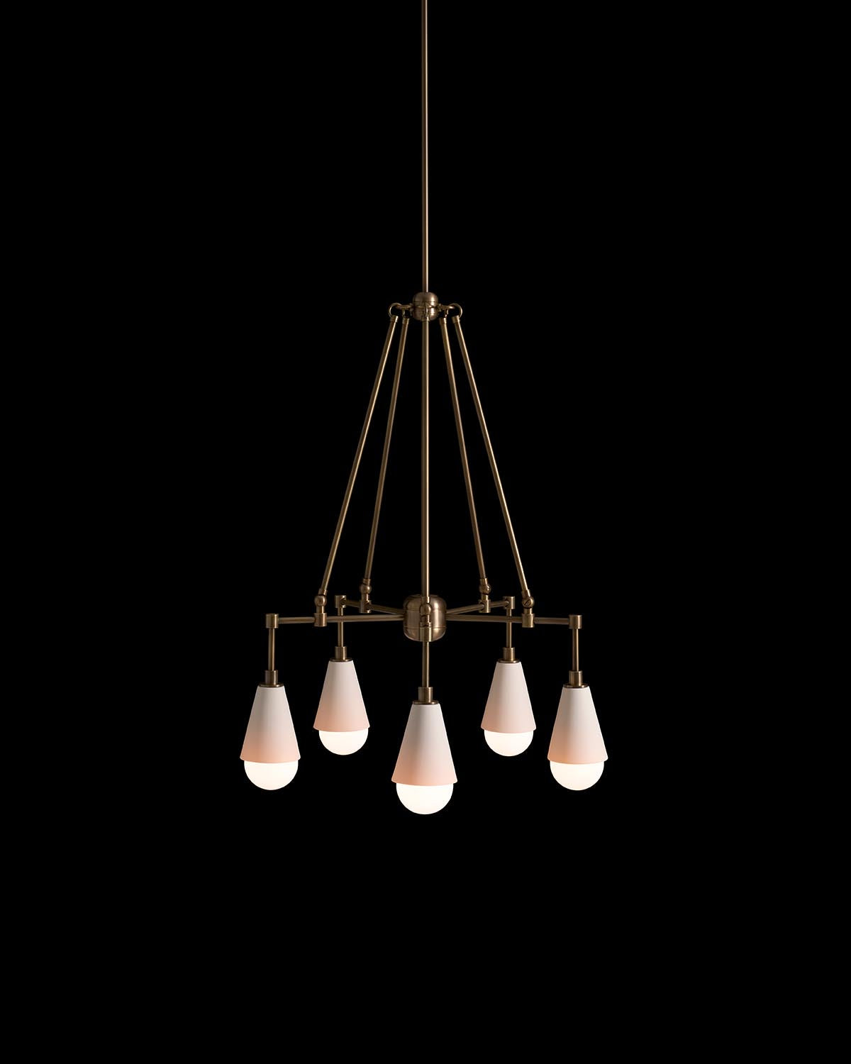 Minimalist five-light pendant fixture with conical white shades and brass metal frame against black background
